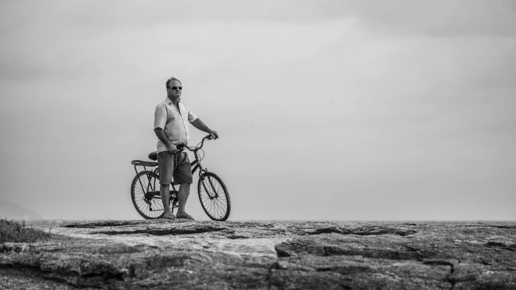 Man standing with a bike on a rocky terrain