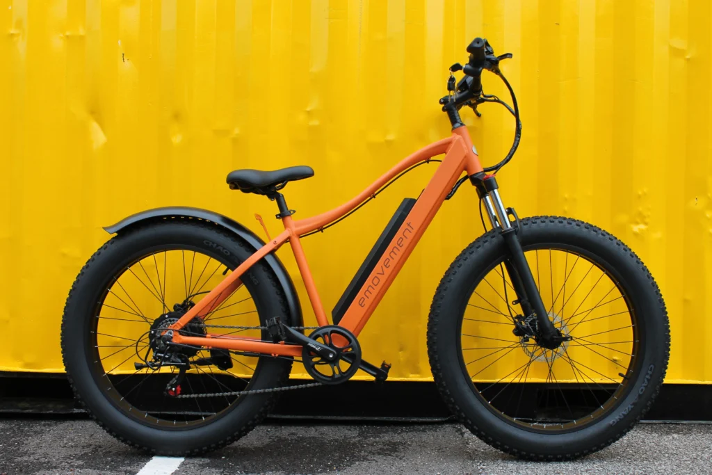 Emovement Thunder: Orange fat tyre mountain ebike against a yellow background